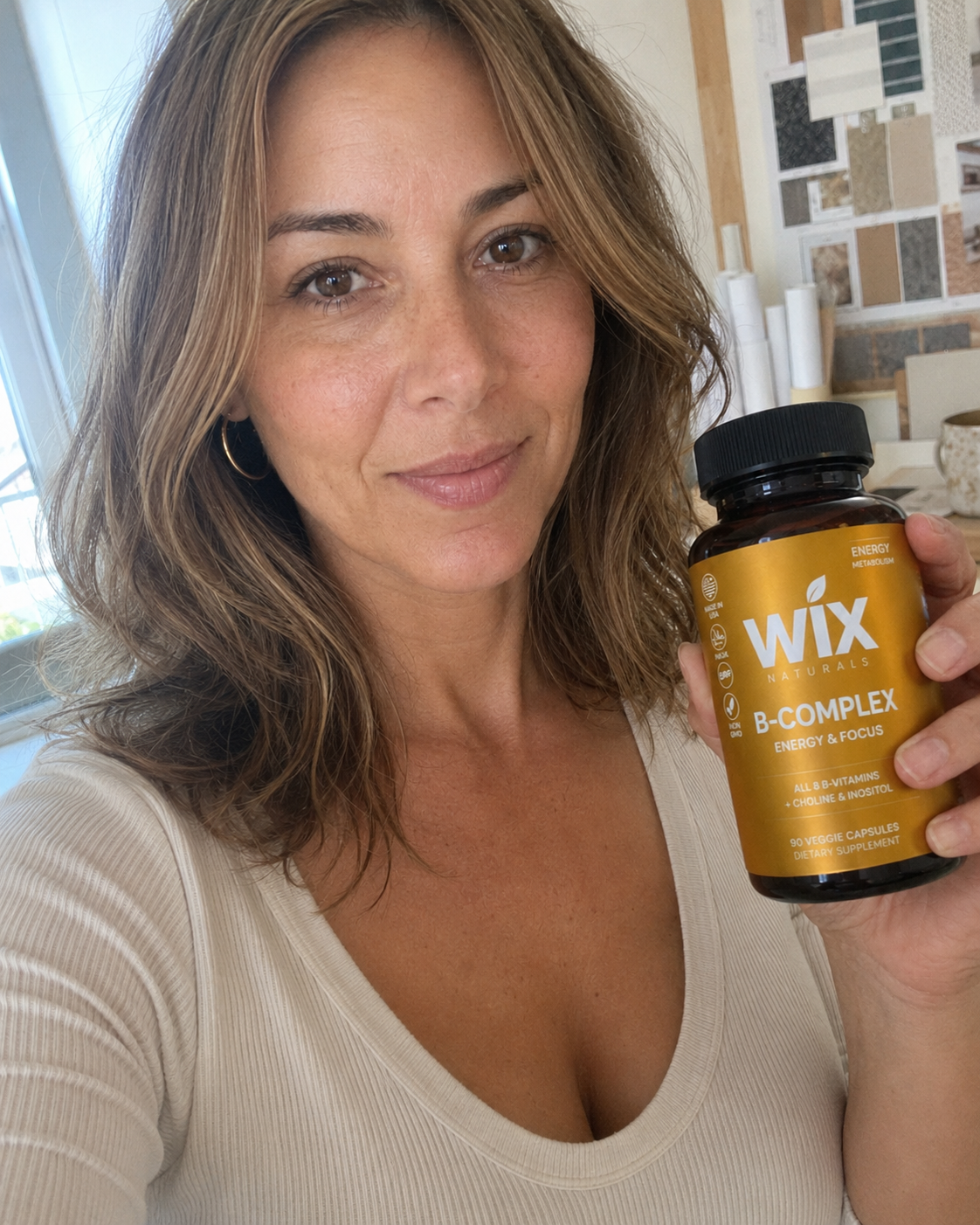 Maya holding WIX Naturals B-Complex in her design studio